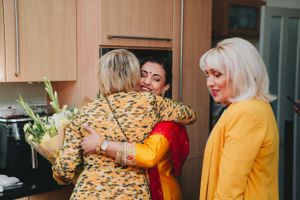 People sharing warm embraces during a celebratory gathering.