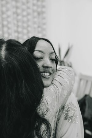 Black and white portrait capturing an emotional embrace during a celebration.