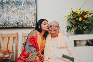 A tender moment captured between a young woman in traditional dress and an elderly person.