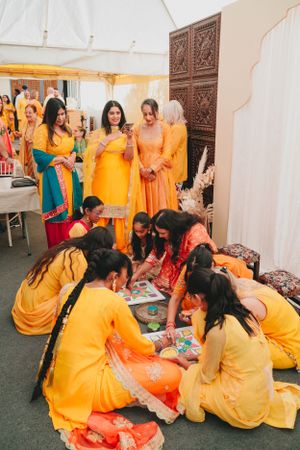Group gathered in yellow and orange attire participating in a cultural art activity.