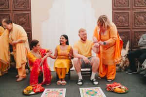 Group gathered in colorful traditional Indian outfits and orange attire during a cultural celebration.