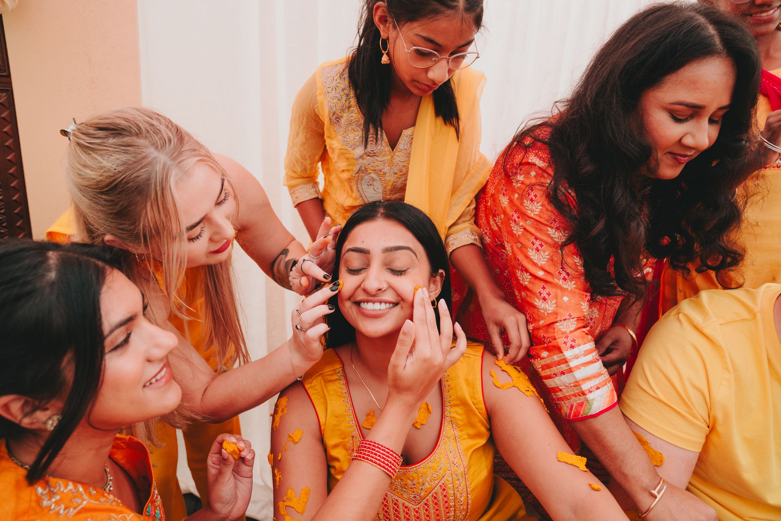Friends share an intimate moment of laughter and joy during a cultural celebration.