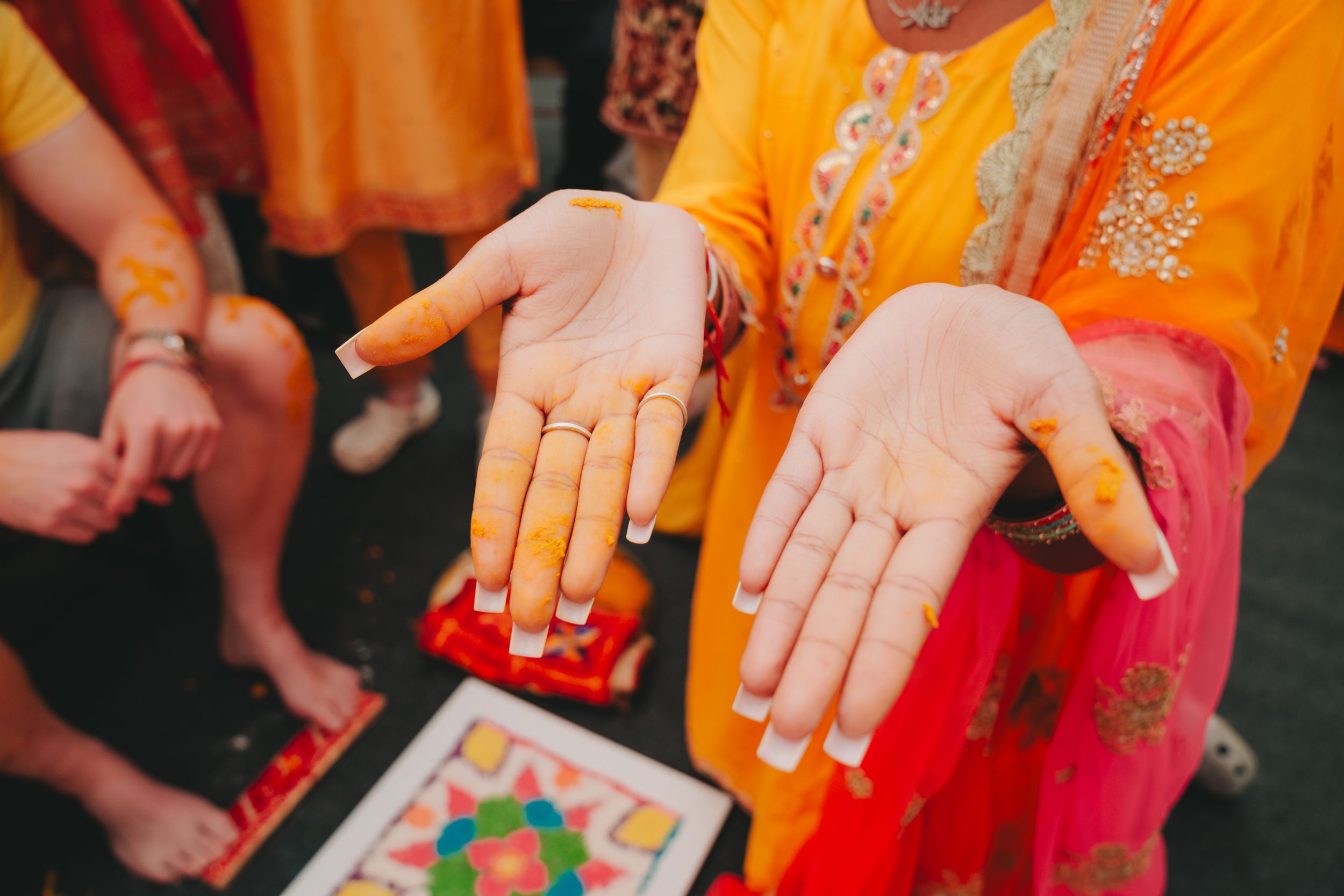 Hands adorned with henna designs showing traditional mehndi art during an Indian ceremony.