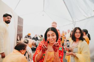 People enjoying festivities in a white tent decorated for a traditional Indian celebration.