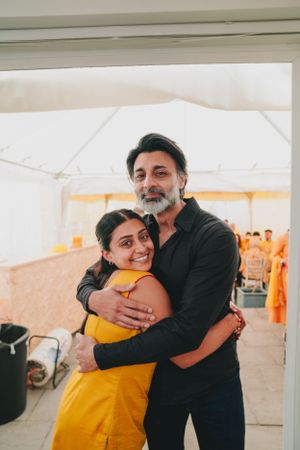 A warm embrace between two people during what appears to be a cultural celebration.