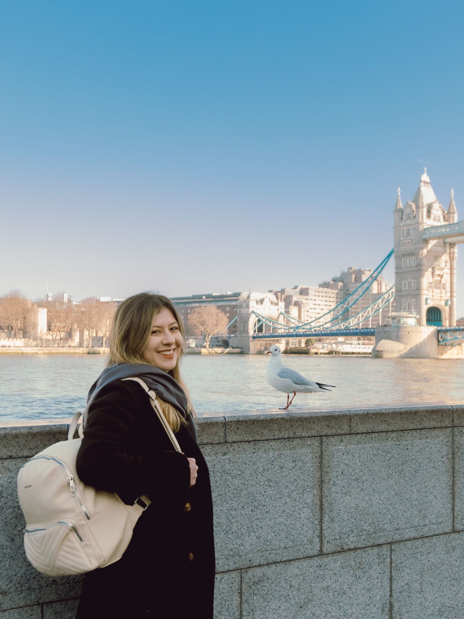 Tourist with backpack enjoying view of Tower Bridge and Thames River in London.