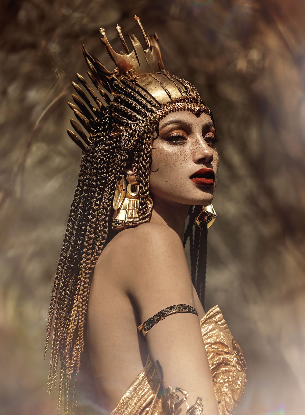 Fashion and beauty portrait of a model in an ornate gold headdress and jewellery