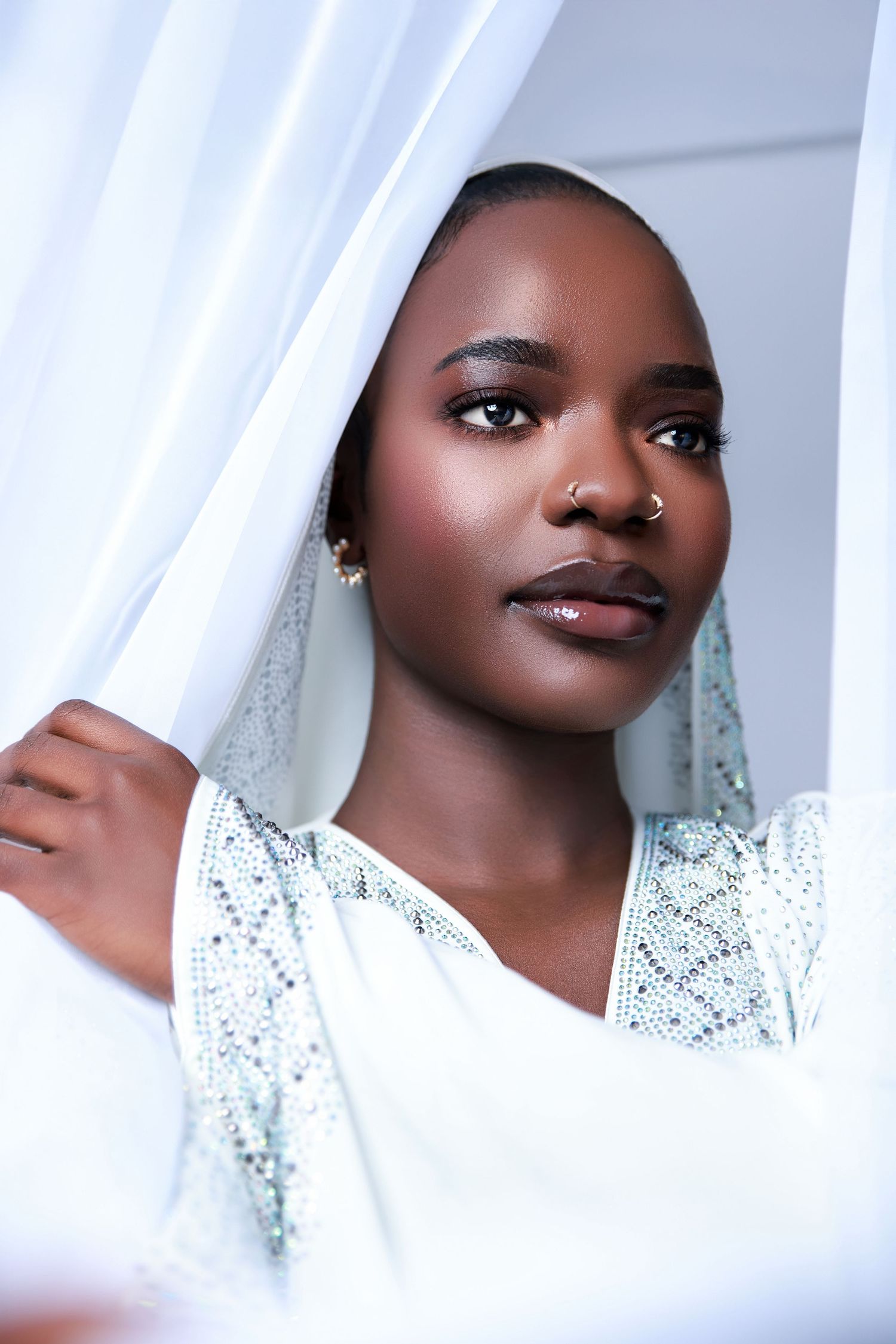 Elegant white hijab portraits with sparkly details and soft lighting.