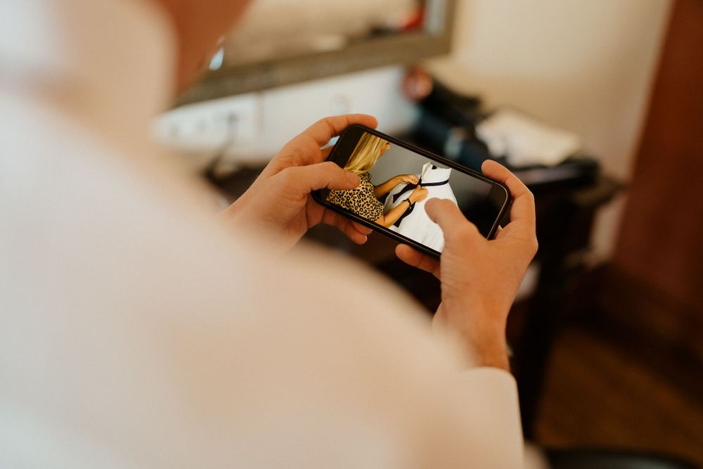 Close-up shot of hands holding a video game controller during pre-wedding preparations.