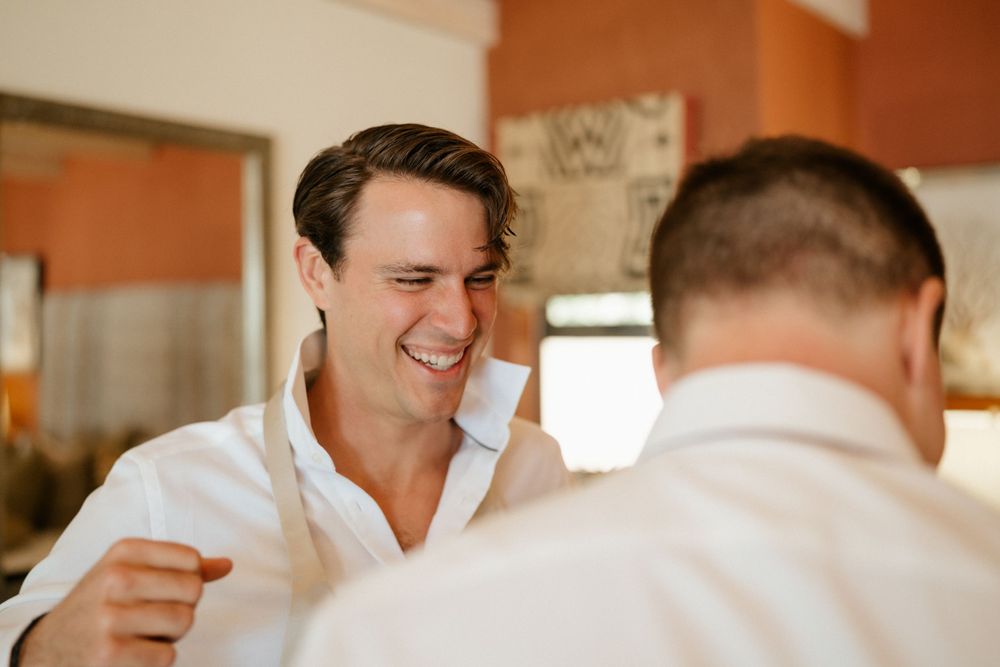 Two people share a candid laughing moment during a casual indoor gathering.