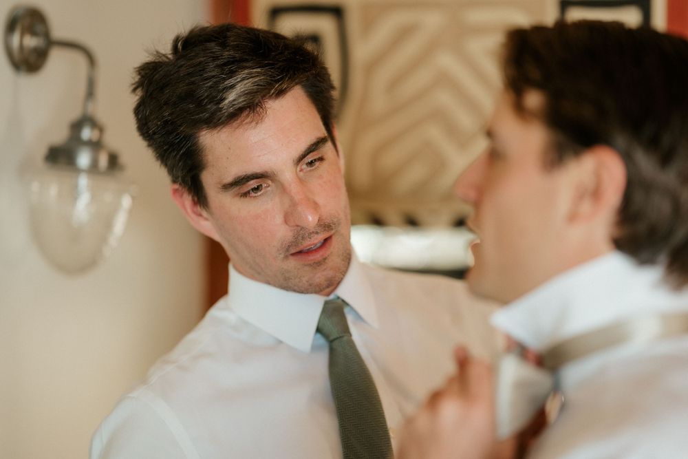 Two people in formal attire having an intimate conversation in a room with wall sconces.