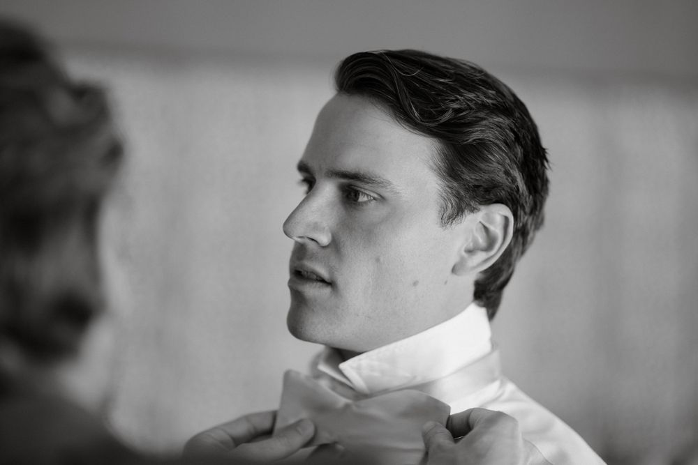 Classic black and white close-up portrait of well-dressed person wearing white collared shirt.