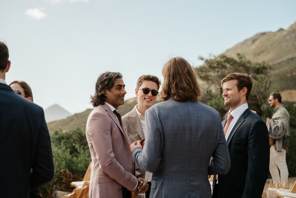 Wedding guests mingling outdoors with scenic mountain views in the background.