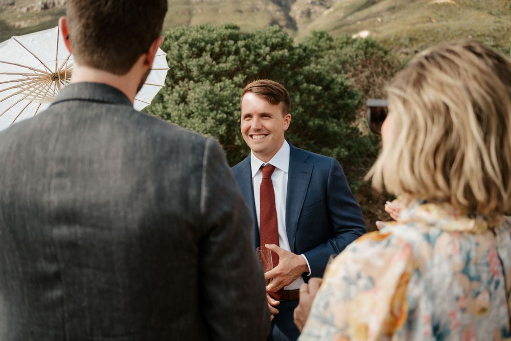 Wedding guests engaged in conversation at an outdoor reception.