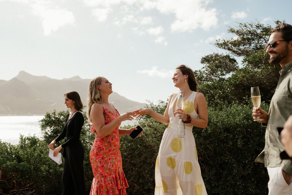 Guests celebrating at a scenic outdoor wedding reception overlooking mountain vistas.
