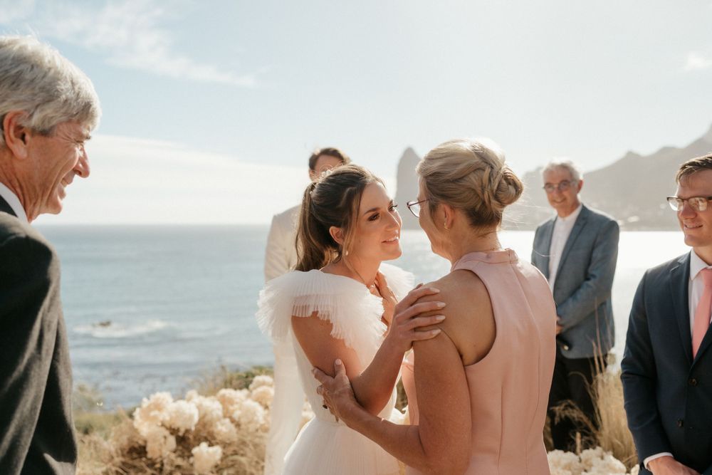 A beautiful ocean view wedding ceremony with guests gathered to celebrate the couple.