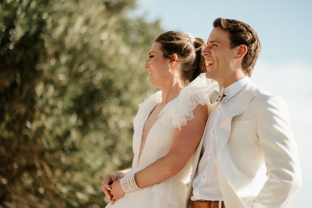 Couple shares a joyful moment together during their sunny outdoor wedding ceremony.