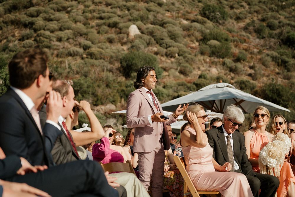 Wedding guests enjoying an outdoor celebration against a scenic mountain backdrop.