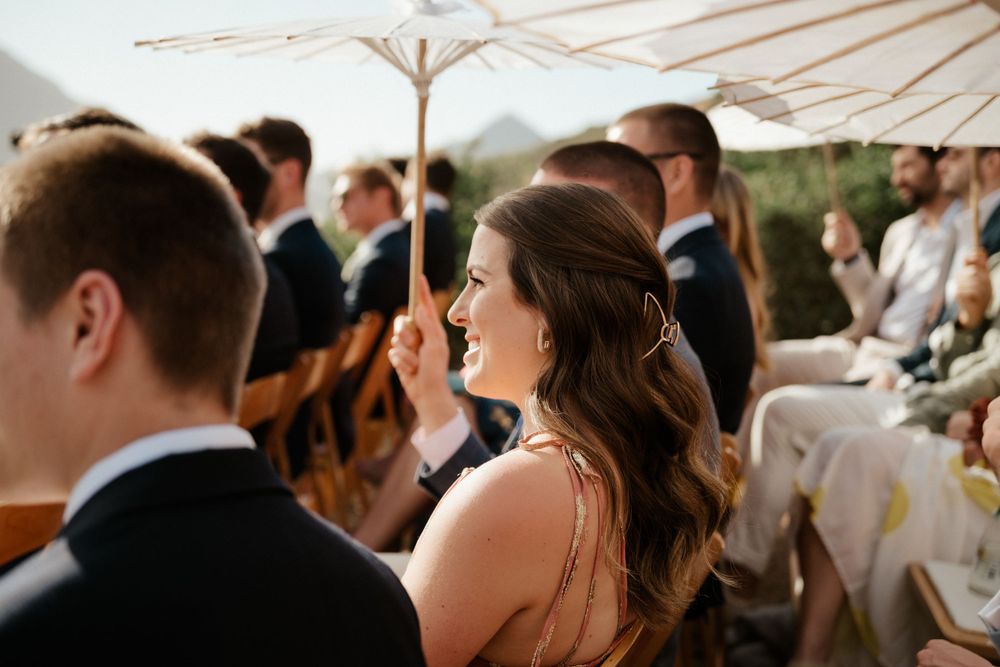 Guests mingle under white parasols at an elegant outdoor wedding reception.