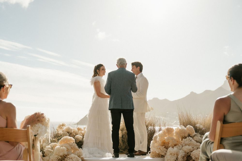 Outdoor mountain wedding ceremony with white floral decorations.