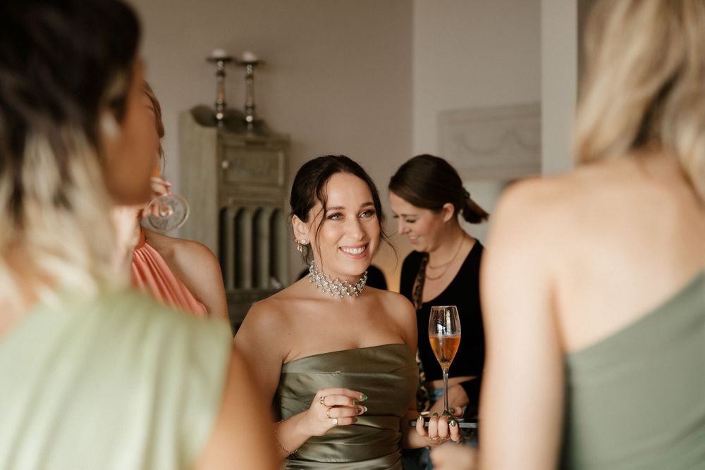 Wedding party getting ready in sage green dresses before the ceremony.