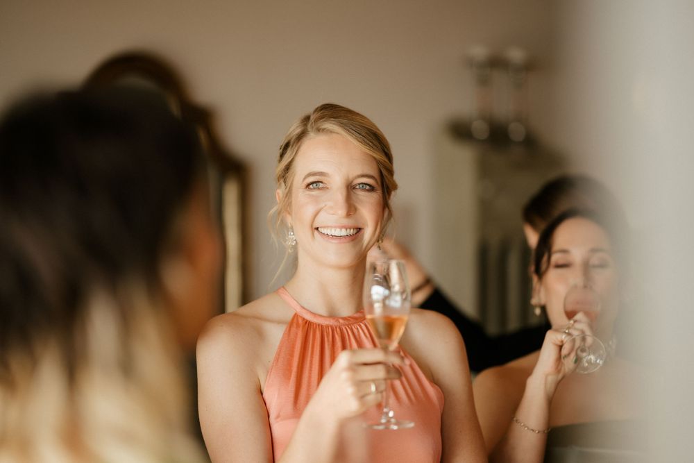 Wedding party members enjoying champagne during pre-ceremony preparations.