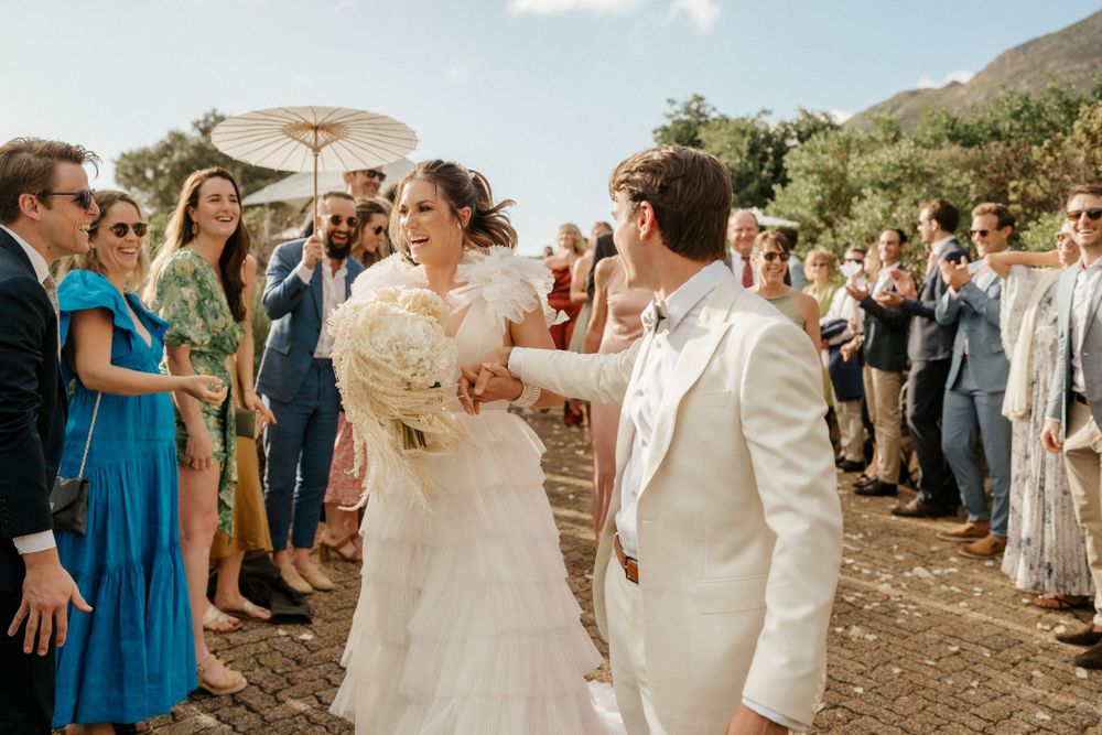 Joyful celebration during outdoor wedding ceremony with mountain backdrop.