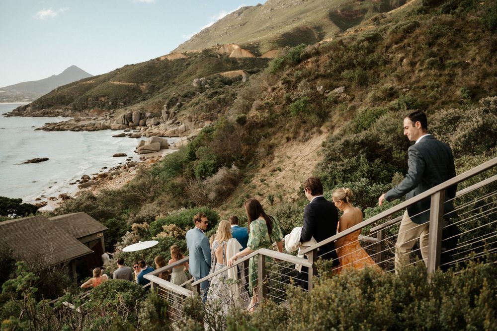 Wedding guests enjoying coastal views from a mountainside overlook.