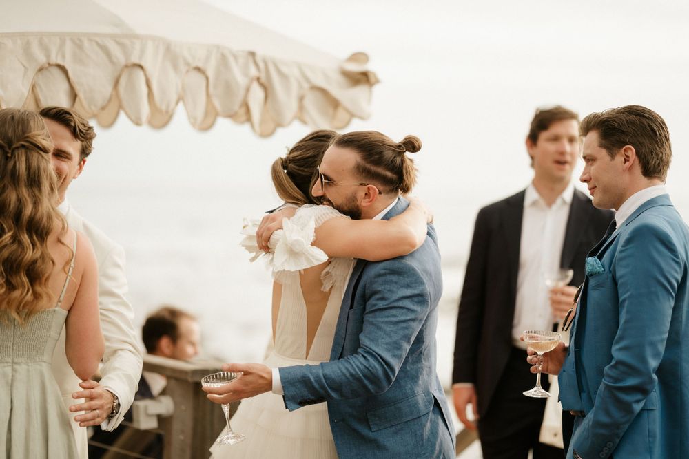 Celebratory moment at an outdoor wedding reception with white draped decor.