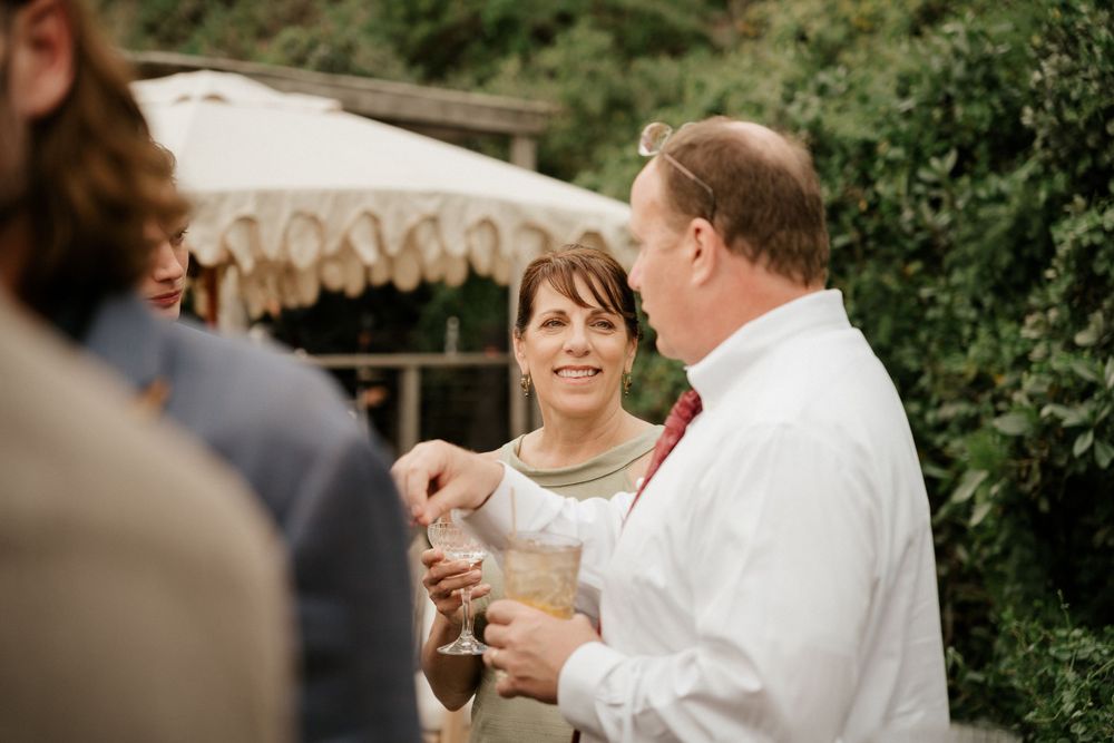 Wedding guests enjoying drinks and conversation during an elegant outdoor celebration.