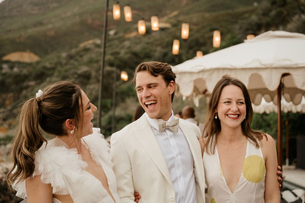 Wedding celebration at dusk with lantern-lit mountains in the background.