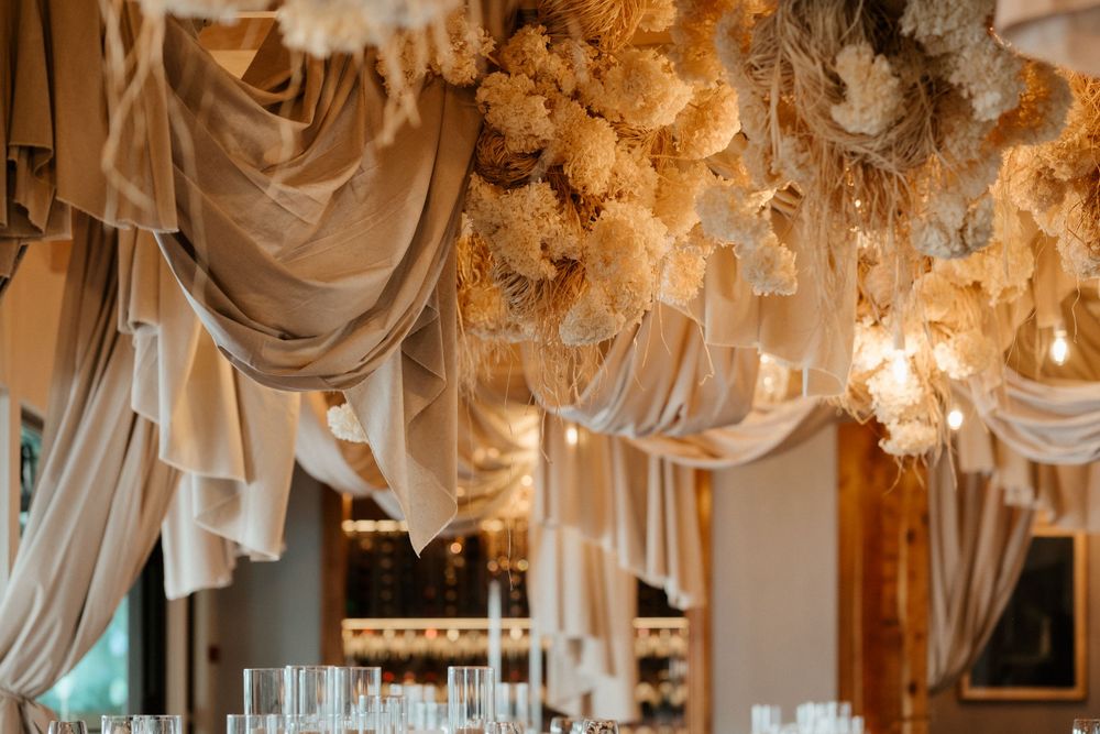 Romantic reception venue with ceiling drapes and ethereal lighting details.