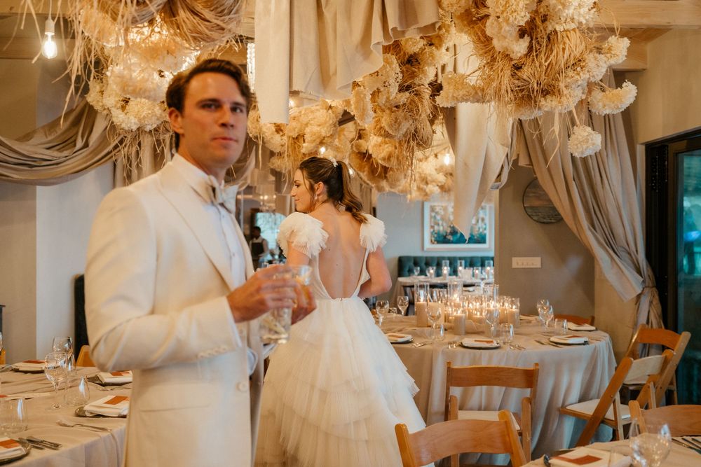 Wedding reception venue decorated with elegant dried flowers and chandeliers.