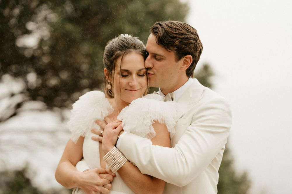 Intimate moment between couple in formal attire embracing outdoors.