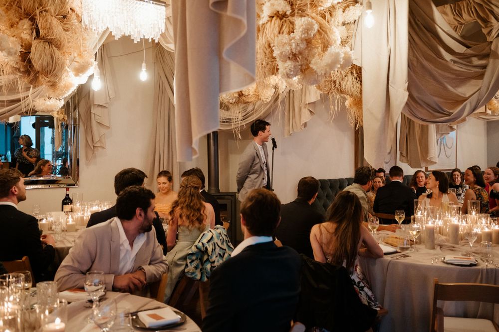 Wedding reception dinner with romantic lighting and ornate ceiling decorations.