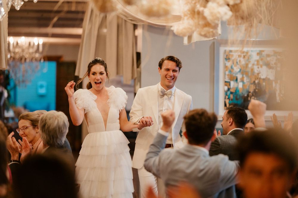 Joyful newlyweds dancing and celebrating during their wedding reception.