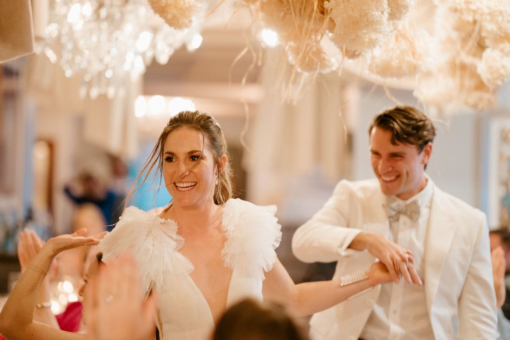 Couple dancing under crystal chandeliers at their wedding reception.