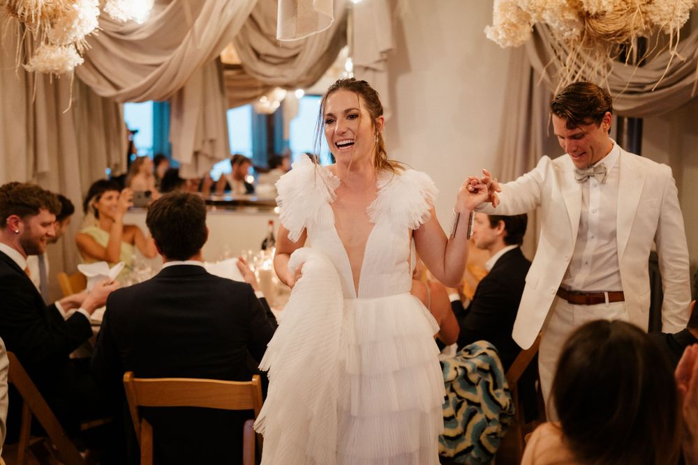 Reception celebration with elegant white decor and dancing.