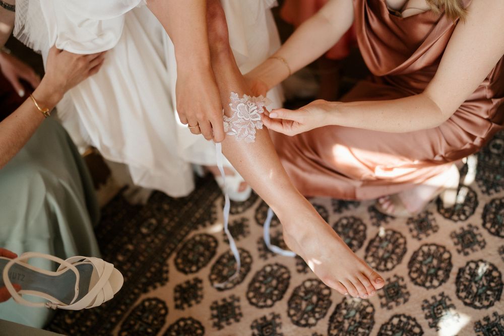 Close-up of wedding preparations showing hands fastening a delicate bracelet.