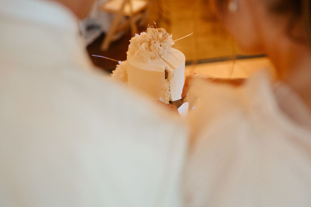 Wedding reception table detail showing a glass with floral decorations in soft focus.