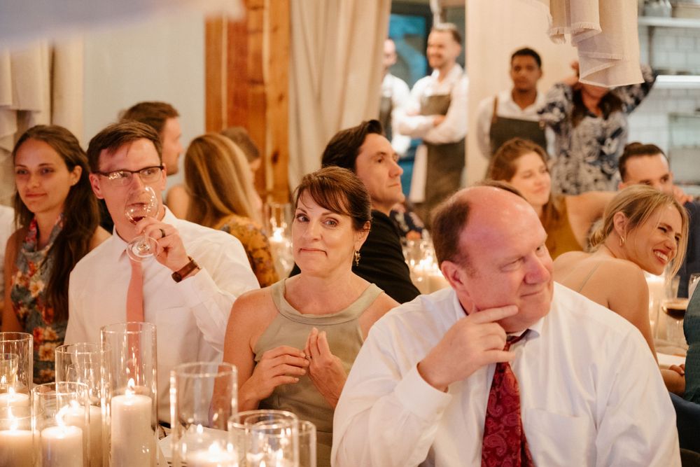 Wedding guests enjoy dinner at an elegant candlelit reception.