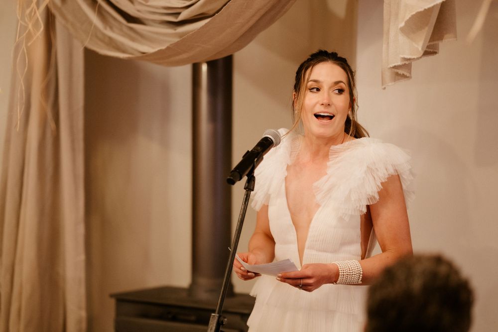 Emotional wedding speech being delivered at an elegantly decorated indoor venue.