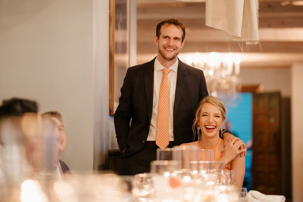 A candlelit wedding reception scene with guests seated at decorated tables.