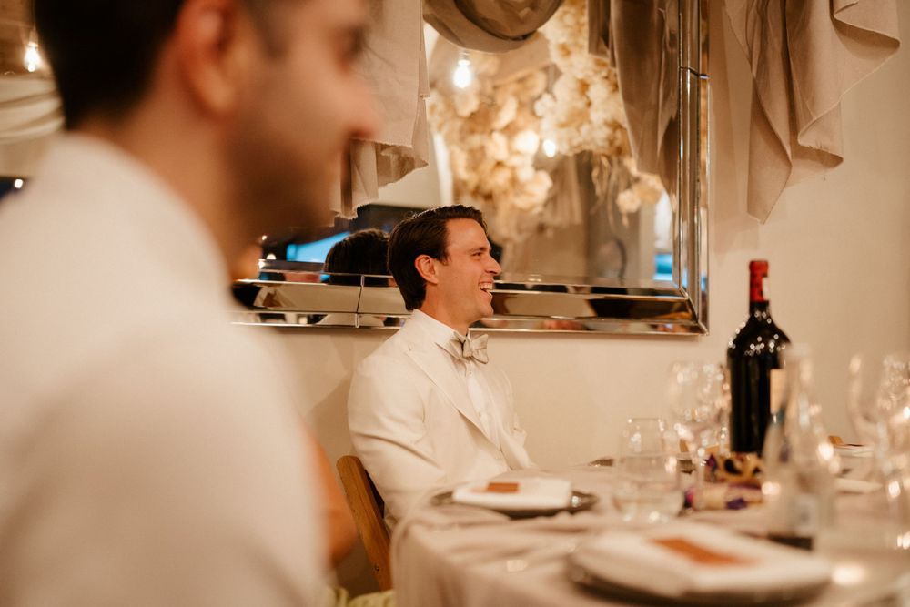 Warm candlelit reception dinner with guests enjoying conversation at an elegant table setting.