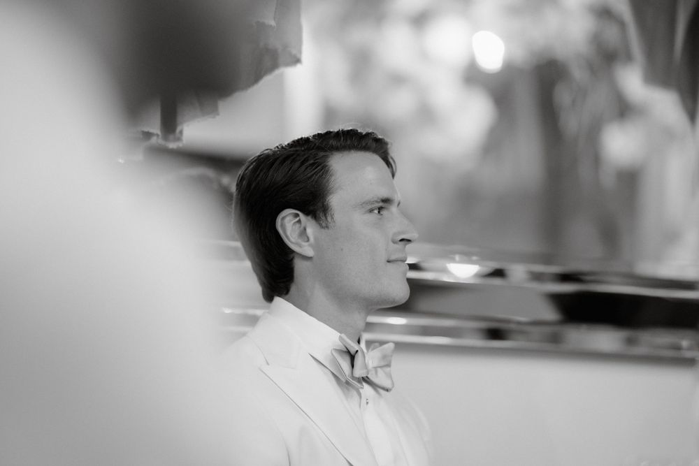 Classic black and white portrait of a groom in formal attire.