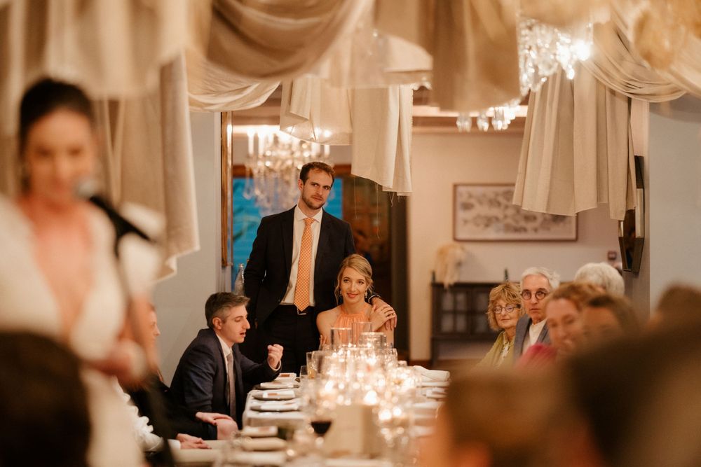 Elegant indoor wedding reception with draped fabric decor and candlelit table settings.