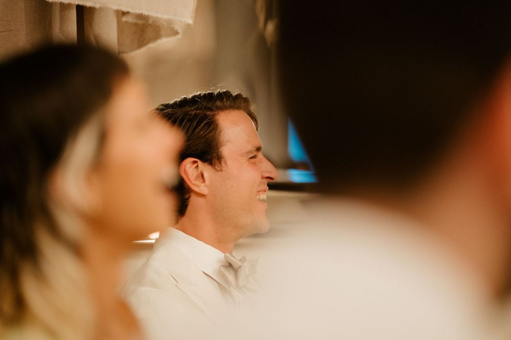Candid reception moment capturing joyful laughter in warm lighting.