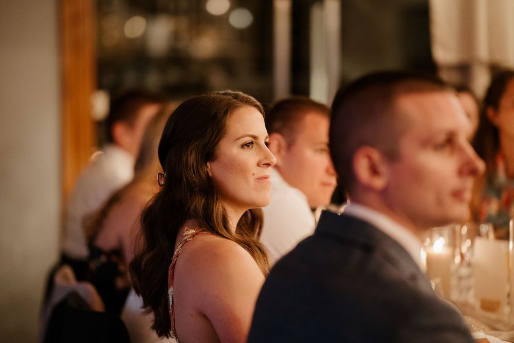Guests enjoying an elegant candlelit wedding reception dinner in formal evening attire.