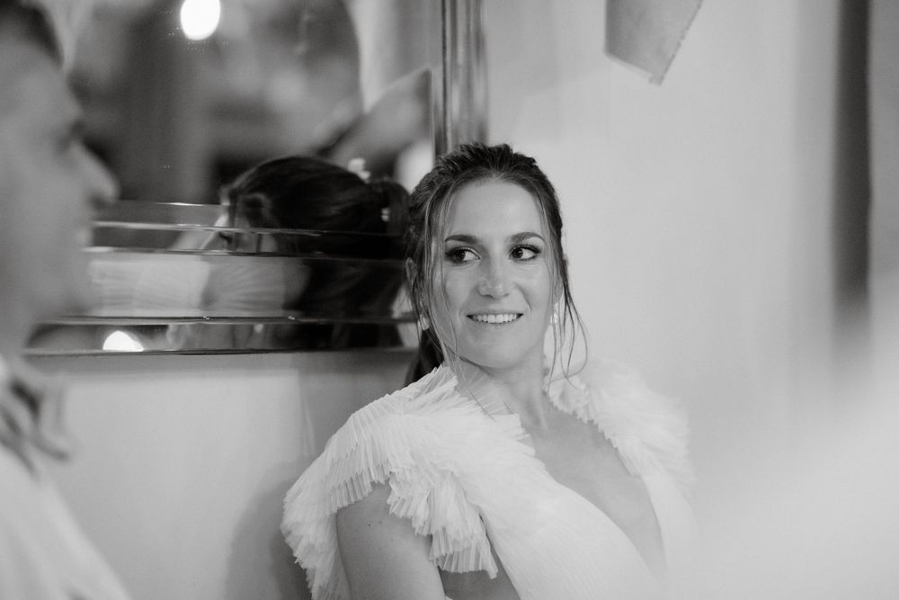 Black and white portrait capturing a candid moment during wedding preparations.