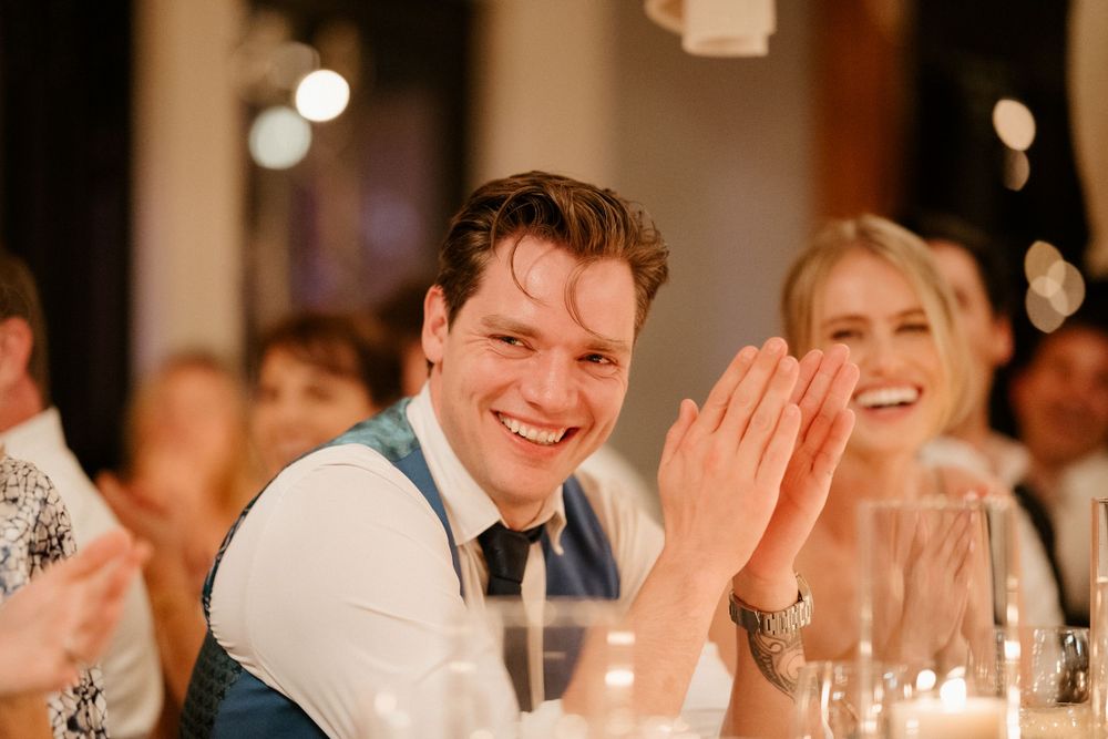 Reception guests share a joyful moment during wedding dinner celebrations.